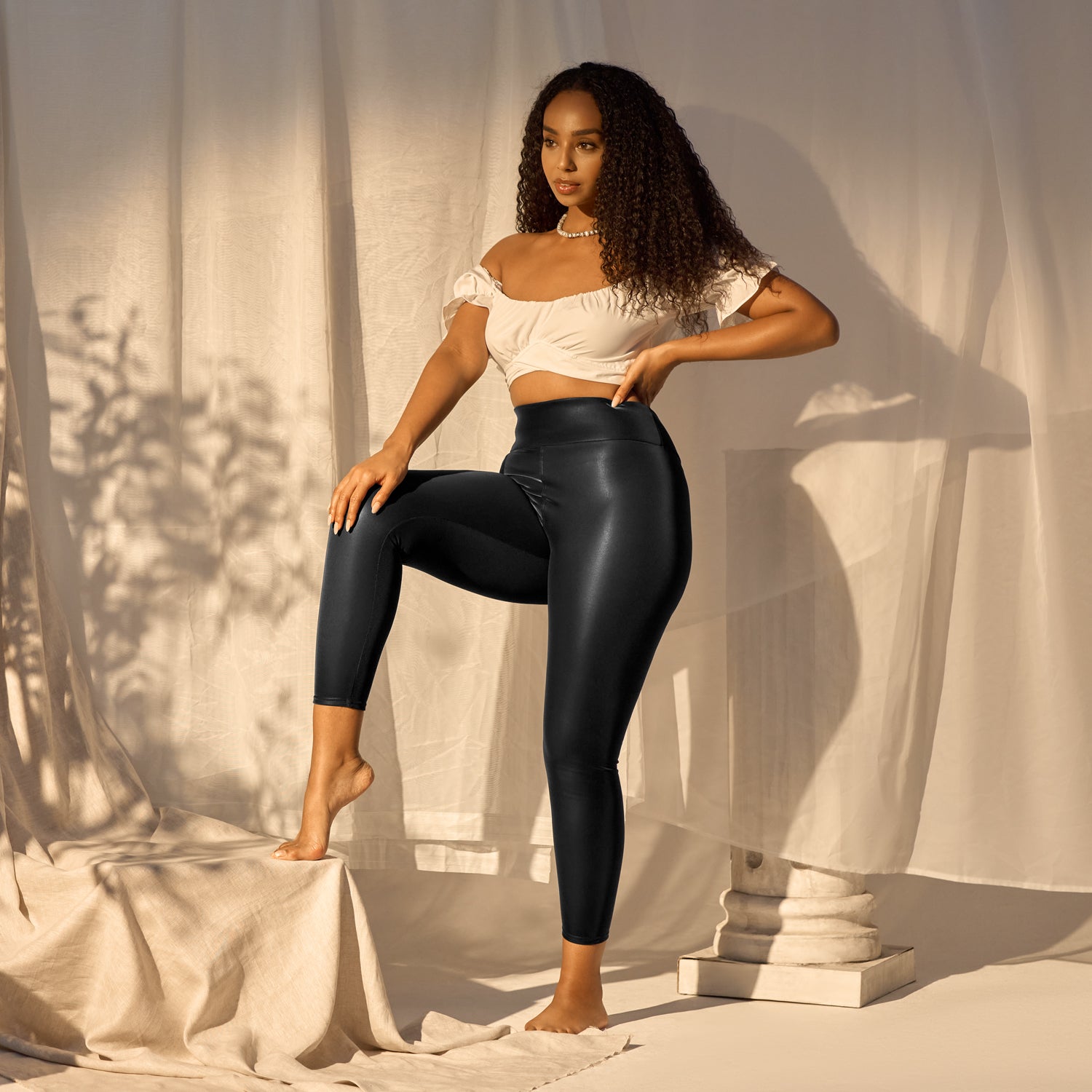 Woman modeling Gaia Luxury Women's Faux Leather Leggings in black; high-waisted, shiny, and eco-conscious activewear.